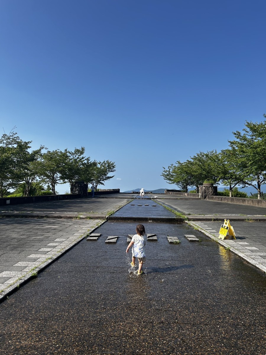 大野城いこいの森中央公園の水路でスリッパを履いて水遊びをする子ども