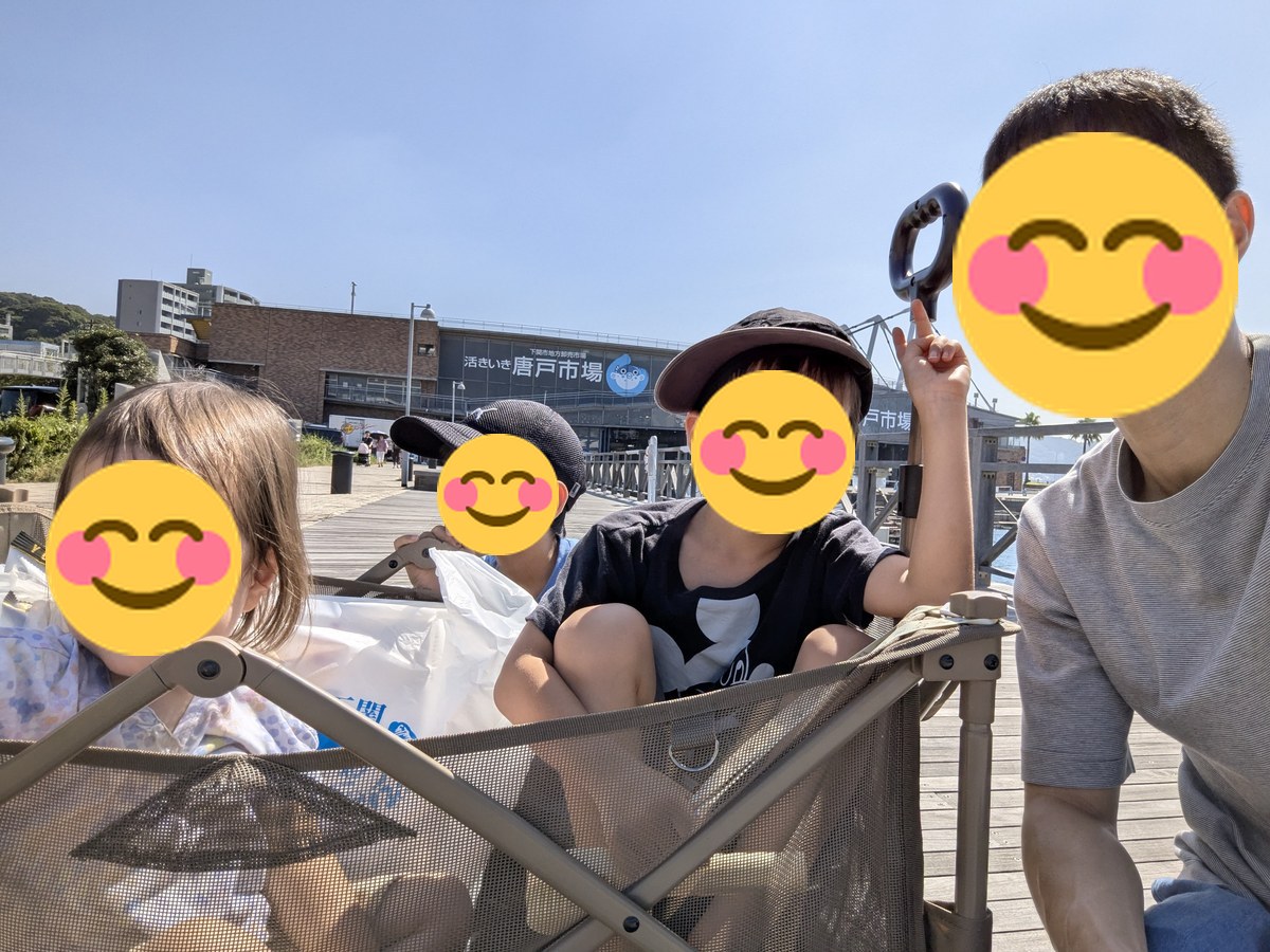 唐戸市場の看板前で記念撮影する家族とキャリーワゴン
